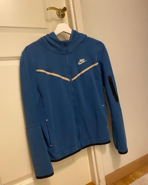 Nike Tech Fleece hoodie - Snygg blå Nike tech fleece hoodie med vita detaljer och Nike logga i storlek s (xl i barn) 