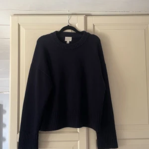 Mörkblå stickad tröja från H&M - Mysig mörkblå stickad tröja från H&M i storlek M. Tröjan har en loose passform, bred ribbstickad kant vid ärmslut och nederkant samt rund halsringning. Knappt använd Hör gärna av dig vin frågor💕💕
