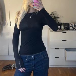 Intimissimi svart tröja - Svart långärmad tröja i tight passform med rund halsringning. Tunt och stretchigt material, perfekt att styla med jeans eller kjol. Ärmarna är extra långa och har råa kanter för en edgy look.