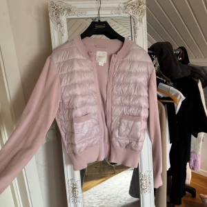 Ljusrosa cardigan jacka från Gina Tricot - Supersöt ljusrosa cardigan jacka från Gina Tricot med quiltad framsida och stickade ärmar. Jackan har dragkedja, två fickor framtill och ribbade muddar. Helt ny som inte kommit till användning ❤️passar xs-s/m