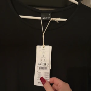 Svart långärmad maxiklänning Gina Tricot - Svart långärmad maxiklänning från Gina Tricot i mjuk jersey. Klänningen har rund halsringning och är figurnära med ett stilrent uttryck. Perfekt för dig som gillar enkel och clean stil. Materialet är stretchigt och följsamt.