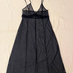 Prickig meshklänning från Zara - Supersöt midiklänning i mesh från Zara med tunna axelband och vita prickar på marinblå botten. Lätt och luftig modell med v-ringning och flowig passform, perfekt att styla lager på lager. Storlek XS. Använd en gång.