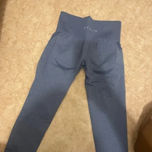 Blå  seamless leggings från NVGTN - Snygga blå seamless leggings från NVGTN med hög midja och tight passform. De har bred resår i midjan och diskreta konturdetaljer bak för en snygg siluett. Perfekta för träning eller chill. Materialet är stretchigt och mjukt för maximal komfort.