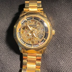 Guldig klocka  - Jätte fin Guldig klocka köpt från Sverige. Det är aoutomatisk så den behöver inga batterier 