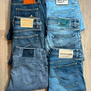 Jacob Cohën jeans i olika blå nyanser 6 st - Flera par Jacob Cohën jeans i olika blå tvättar, från ljusblå till mörkblå och ett par i gråblått. Klassisk femficksmodell med snygga detaljer på bakfickorna och unika patchar i olika färger och material. Perfekta för dig som gillar premiumjeans med stil.