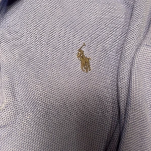 Blå half zip tröja från Polo Ralph Lauren - Säljer en blå långärmad tröja från Polo Ralph Lauren med half zip och klassisk broderad logga på bröstet. Tröjan är stickad i bomull och har ribbade muddar vid ärmslut och nederkant. Perfekt för lager-på-lager och chill stil.