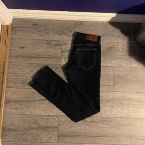 Mörkblå skinny jeans Tiger of Sweden - Snygga mörkblå slim jeans från Tiger of Sweden. Klassisk femficksmodell med guldfärgade sömmar och läderpatch bak i midjan. Jeansen har en slim passform och är tillverkade i ett stretchigt denimtyg för extra komfort.