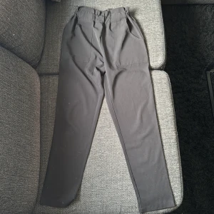 Svarta byxor från Dennis Maglic XS - Svarta byxor från Dennis Maglic i storlek XS. De har resår i midjan, raka ben och sidfickor framtill. Materialet känns mjukt och lätt. Fint skick!