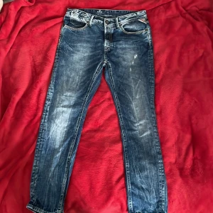 Replay blå jeans  - Tja! Säljer ett par snygga blåa jeans från Replay med klassisk femficksdesign. Jeansen har slitna detaljer och kontrastsömmar på bakfickorna. En unik tvättning som ger dig en skön look. Är storleken w27 men skulle säga att den mer är w28 till w29 i midjan. Hör av dig vid intresse