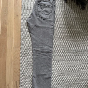 Jack & Jones jeans - Snygga grå jeans med klassisk femficksdesign. Jeansen har en enkel look med raka sömmar och diskreta bakfickor. Perfekta för dig som gillar en stilren och clean vibe. Längd 32 - Midja 28