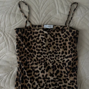 Leopardmönstrad topp från Envii - Säljer en snygg leopardmönstrad topp från Envii med tunna axelband. Toppen har en beige bas med svarta och bruna fläckar, perfekt för dig som vill sticka ut. Modellen är figurnära och passar perfekt till sommarens alla tillfällen.