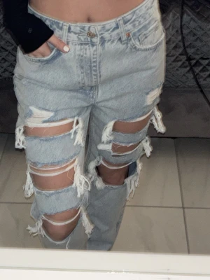 Ljusblå ripped jeans med fransar - Ljusblå jeans med slitna hål, hög midja och raka ben. Oanvända.