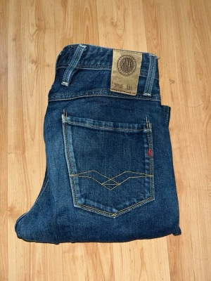 Replay jeans  - Säljer ett par klassiska Replay Blue Jeans i mörkblå tvätt med raka ben och snygga kontrastsömmar. Midja 36cm, längd 104cm. JAG SKICKAR EJ FLER BILDER NÄR JAG BÄR JEANSEN! för bättre inblick i passformen rekommenderar jag att googla på modellnamnet. För storleksguide kolla måtten noggrant då jeansen alltid kan vara uppsydda heller krympta och jag ej tar emot returer :) 1,13