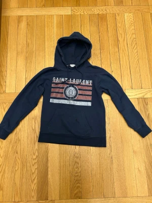 Saint Laurent hoodie  🔥🔥🙌🙌 - En riktigt snygg Saint Laurent Hoodie i mörkblå med print. Passar till det mesta. Stl S. Hör av er vid funderingar, jag svarar gärna☺️