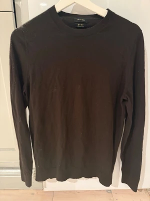 Brun merinoulltröja Massimo Dutti - Klassisk svart tröja från Massimo Dutti i mjuk merinoull. Enkel design med rund halsringning och långa ärmar. Perfekt att styla lager på lager eller bära som den är. Snygg och tidlös basic som funkar till allt.