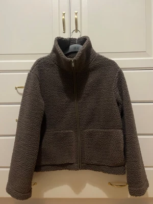 Brun teddyjacka  - Mysig brun teddyjacka från Lager 157 med hög krage och dragkedja framtill. Supersnygg till våren!