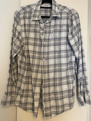 Rutig skjorta från Weekday - Säljer en vit och svart rutig skjorta från Weekday. Storlek M.