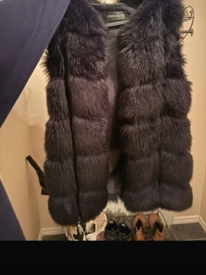 Päls väst - Säljer denna snygga pälsväst. Inte använt på flera år. Använt fåtal gånger. Varm, skön och snygg!
