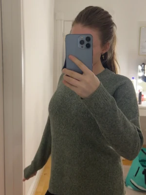 Grön stickad tröja från Vero Moda - Mysig grön stickad tröja från Vero Moda i storlek XS. Tröjan har rund halsringning, långa ärmar och ribbade muddar. Perfekt att slänga på sig när det är kyligt ute. Snygg till både jeans och kjol!