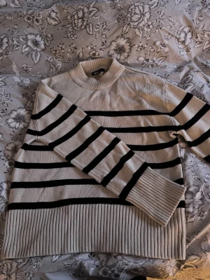 Randig beige och svart stickad tröja - Säljer en svart/beige stickad tröja från Gina som inte kommer till användning längre!