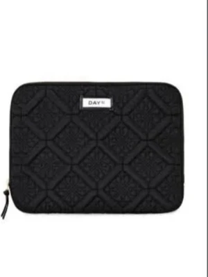 Svart datorfodral  - Snygg svart quiltad datorfodral från DAY med diskret mönster och dragkedja. Perfekt för att bära din laptop i stil. Väskan har en stilren look och är lätt att matcha med allt.