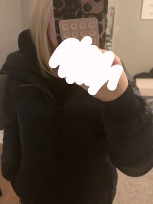 Svart pufferjacka Peak Performance XS - Säljer en svart pufferjacka från Peak Performance i storlek XS. Jackan har huva, dragkedja framtill och är tillverkad i syntetmaterial. Perfekt för kalla dagar och har en klassisk, enkel look. Det finns ett synligt hål som man kan säkert laga men resten av dom på armen är ej synliga . annars väldigt fint skick 