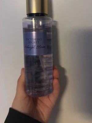 Victoria's Secret Midnight Bloom mist - Midnight Bloom från Victoria's Secret är en body mist med volym 250 ml. Flaskans baksida beskriver doften med 'Moon flower. Creamy woods. Star-crossed lover.' Ingredienser inkluderar vatten, glycerin, parfym, ricinolja m.m. Tillverkad i USA och Storbritannien. Den är lite använd men jag har slutat använda parfymen