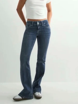 Blå bootcut jeans med låg midja - Säljer ett par blå bootcut jeans med låg midja och snygga detaljer på bakfickorna. Perfekt nu på vinter 🩷 Storlek 32 men passar även 34 som jag har i vanliga fall.