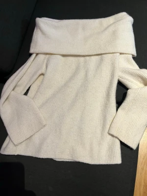 Beige offshoulder stickad tröja H&M S - Säljer en superfin vit stickad tröja från H&M i storlek S. Tröjan har offshoulder-design med bred krage och långa ärmar. Perfekt för dig som vill ha en mysig men ändå stilren look till hösten eller vintern.