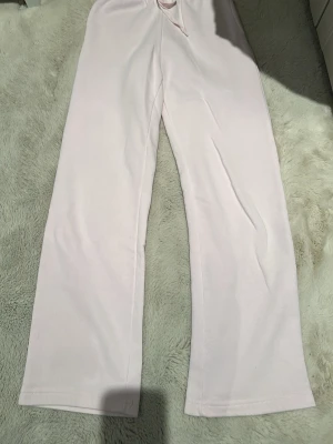 Ljusrosa mjukisbyxor Gina Tricot XXS - Supersköna ljusrosa mjukisbyxor från Gina Tricot i storlek XXS. Byxorna har resår i midjan och raka ben för en chill vibe. Tillverkade i mjukt bomullsmaterial som känns riktigt nice mot huden. Perfekta för att mysa runt hemma eller när du vill vara extra comfy. Har knappt använt heller, har för mycket byxor just nu. 