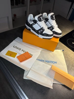 Louis Vuitton trainers - Louis Vuitton sneakers i svart och vitt med ikoniskt monogrammönster. Skorna har snörning, platt sula och detaljer i både skinn och textil. Tydliga LV-loggor på plös och sidor. Kommer med originalkartong, dustbag och certifikat. Kvitto finns, pris kan diskuteras❗️