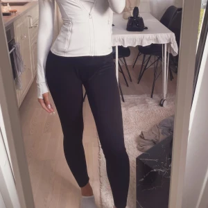 Svarta ribbade leggings - Säljer ett par svarta leggings med ribbad struktur. De är tighta och sitter snyggt längs benen, perfekta för en clean och enkel look. Materialet är mjukt och stretchigt, vilket gör dem riktigt bekväma att ha på sig hela dagen.