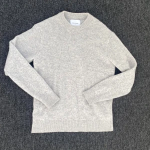 Ljusgrå merinoullströja från Vailent - En stilren ljusgrå stickad tröja från Vailent i mjuk merinoull. Tröjan har rund halsringning, ribbade muddar och klassisk passform. Perfekt för lager-på-lager under kyliga dagar.