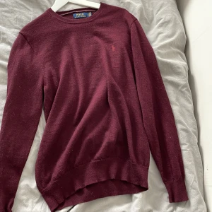 Vinröd merinoullströja Polo Ralph Lauren - Säljer en vinröd långärmad tröja från Polo Ralph Lauren i slim fit. Tröjan är gjord i mjuk och tvättbar merinoull, har rund halsringning och diskret broderad logga på bröstet. och snygg till både jeans och chinos. De står L men sitter mer som S perfekt för dig som vill sticka ut lite mer än dom andra. Hör gärna av dig om du har frågor.🤗
