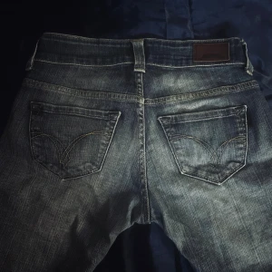 Levi's 504 blå jeans  - Klassiska Levi's 504 jeans i blå tvätt med snyggt slitna detaljer. Materialet är robust denim i bomull.