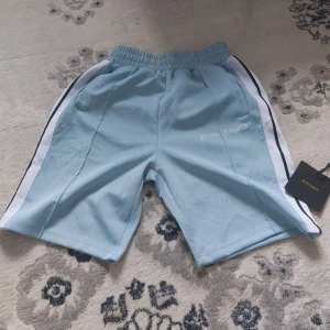 Ljus blå Palm Angels Shorts M - Brand: Palm Angels Size ● Medium ● Använd några gånger bara, väldigt bra skick. ● Fraktar inom 24h ● Vid frågor eller intresse, dm :)