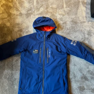 Sail Racing Jacka - Hej  Säljer denna sail racing jacka. Det är en gortex jacka så den är perfekt nu inför hösten och vintern. Den är i storlek L. Fint skick inga skador förutom på höger armen se på (bild 5). Fina fickor inuti jackan samt fyra utanpå.  Vid funderingar hör gärna av dig! Mvh