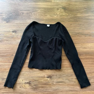Svart långärmad sweetheart topp - Säljer en svart långärmad topp från H&M i storlek S. Toppen har en snygg sweetheart-halsringning och är figurnära i modellen. Materialet är mjuk bomull med lite stretch, perfekt för att ge en skön passform. Enkel och stilren design som är lätt att matcha.