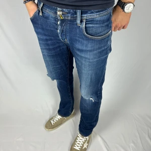 Jacob Cohen 622 Comfort - Jacob Cohën jeans med sköna slitningar/hål av modellen 622 C. Skicket på jeansen är väldigt bra utan större defekter, men dom är välanvända. Retail pris: 4999kr - Modellen är 185cm och väger 80kg. Mått: 100x46 (Ytterben + midja) Hör av dig vid frågor eller funderingar!