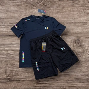Svart träningsset från Under Armour. S, M, L finns! - Säljer ett par svarta träningsshorts från Under Armour med färgglad logga och textdetaljer. Shortsen har elastisk midja och är tillverkade i ett lätt och snabbtorkande syntetmaterial, perfekta för intensiva träningspass.
