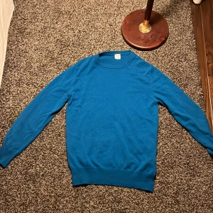 Blå cashmere tröja  - Säljer en stilren blå stickad tröja från italienska Eleventy. Tröjan har rund halsringning, långa ärmar och ribbade muddar vid ärmslut och nederkant. Perfekt för dig som gillar klassisk och enkel design med premiumkänsla. Den kostar typ 6-7 tusen ny och jag bara bara använt den typ 5 gånger jag rekommenderar starkt och bra pris 