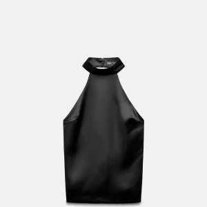 Svart satin polotopp från Zara - Säljer en svart polotopp från Zara i glansigt satinmaterial. Toppen har hög hals med knappar i nacken och är ärmlös med en stilren, tight passform. Perfekt för dig som gillar minimalistisk och elegant stil.