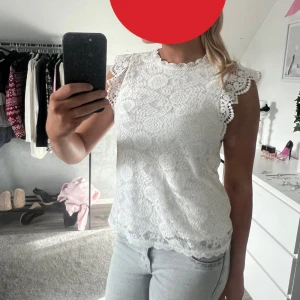 Vit spetsblus med volangärm - Säljer en söt vit blus i spets med fina volangärmar och rund halsringning. Blusen har ett detaljerat spetsmönster och vågig kant nertill. Perfekt för dig som gillar romantisk och feminin stil.