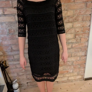 Svart spetsklänning med trekvartsärm - En svart fin klänning med spets som mönster från kappahl. Klänningen är i storlek L men är väldigt stretchig!! Den är i bra skick och är använd några få gånger!! 