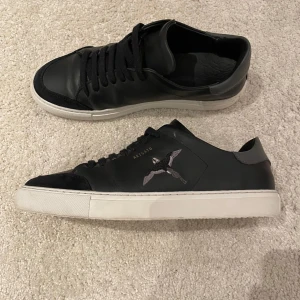   Axel Arigato Clean 90  - Snygga svarta sneakers från Axel Arigato  Skorna är endast använda ett fåtal gånger vilket man knappast ser förutom små ”crease” defekter där fram. En del försvinner när skon sitter på och är i rätt form. Orörd original skolåda för skorna följer med. 