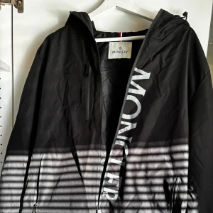 Svart vindjacka från Moncler med huva - Svart vindjacka från Moncler. Knappt använd. Går att hämta i Stockholm (-100kr). Storlek M.