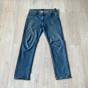 Blå Lee Jeans  - Blåa Lee Jeans West byxor i mycket bra skick! Det är en rak passform och storlek 31/32. Säljer för att de inte används längre. Tveka inte på att höra av er vid minsta lilla fråga eller annat!✌️