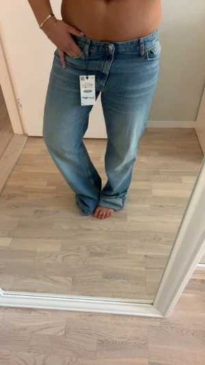 Blå wide jeans från Zara - Säljer ett par ljusblå jeans från Zara med breda ben och klassisk femficksdesign. Populära och slutsålda jeans, jag är 163 och modellen på jeansen är TRF wide leg!!!!storlek 42 men små i storlek!