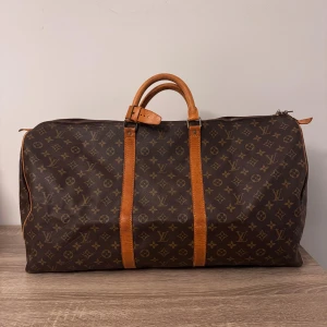 Louis Vuitton Keepall 60 - Skicket är bra överlag på väskan, har lite skönhetsfel på den. Men fin i helhets intryck. Som på bilderna finns de repor på canvas handtagen rätt slitna metall detaljerna är repiga och tappat lite färg. Annars väldigt fin inuti inga fläckar eller hål och dragkedjor funkar. Kanterna är nöttna. Men en bra och fin väska för en billigare peng. Perfekt till lång weekendresa eller julklapp?