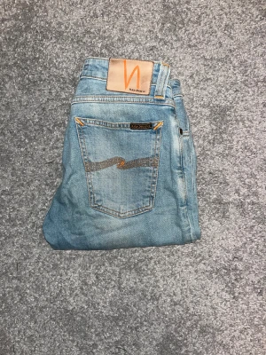 Ljusblå Nudie jeans W28 L30 - Snygga ljusblå Nudie jeans i klassisk fem ficks design. De är i storlek w28 L30. Kontakta mig för frågor, kan gå ner i pris vid snabb affär.